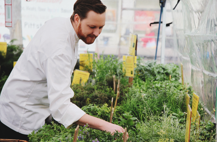 Chef Jeffrey inspecting herbs and plants at the Union Square Farmer's Market
