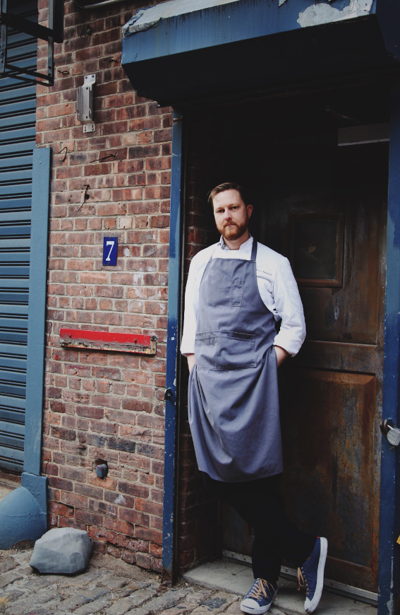 Chef Jeffrey stands, leaning against a doorway